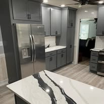 Modern gray kitchen remodel with stainless steel appliances and quartz island
